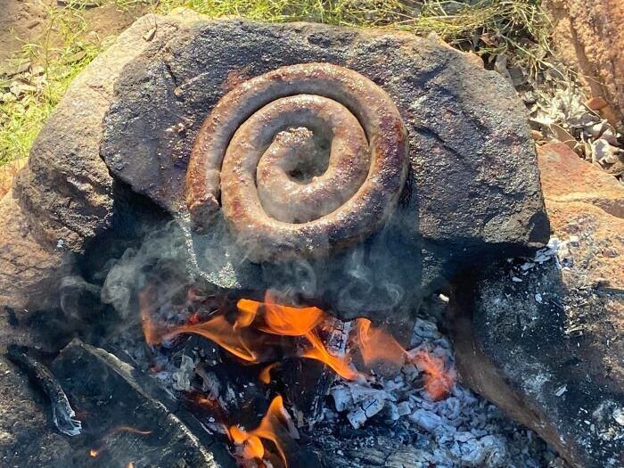 Sausage being cooked over open flames