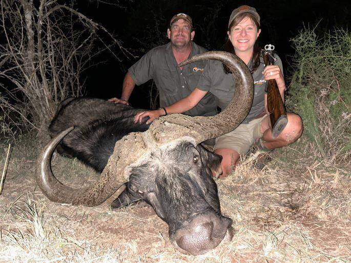 two people posing with a Cape buffalo trophy