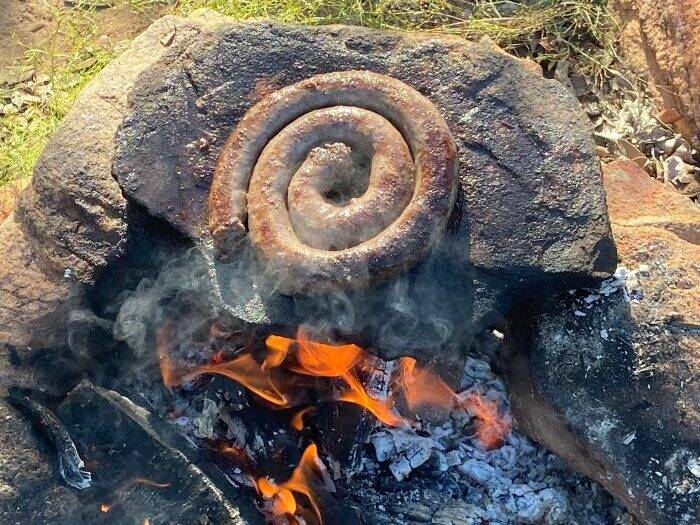 Sausage being cooked over open flames