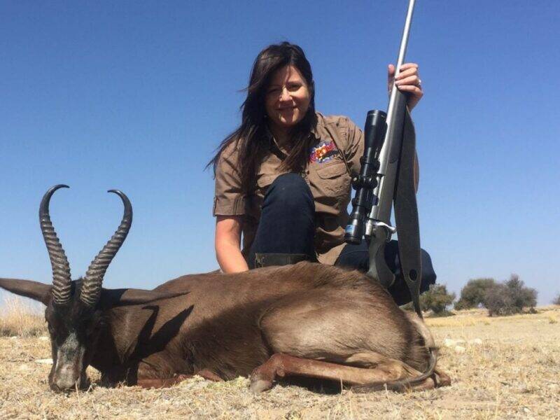 Female with rifle posing with black springbuck she shot